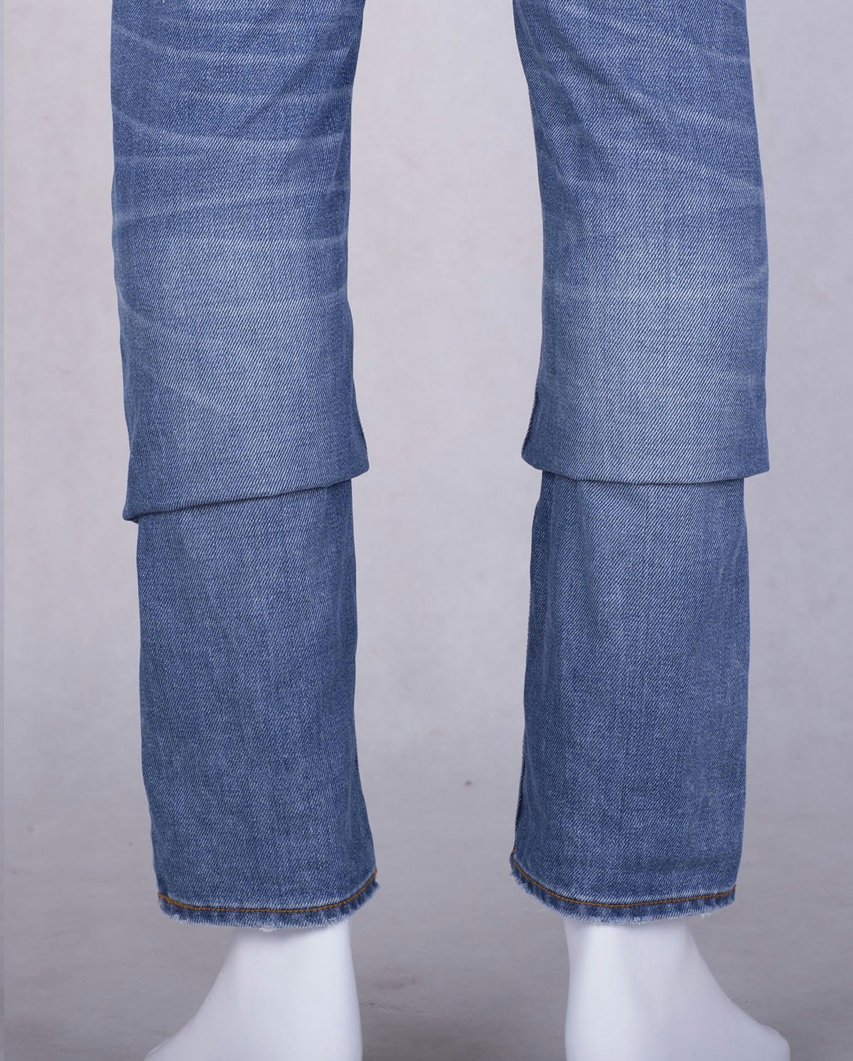 jeans-retouching-pinning-crease-removal-before Product photograph of jeans with pinning mid-leg to make pant strike at mannequin ankle